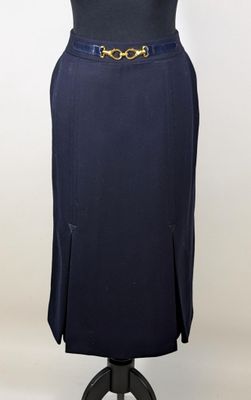 a woman ' s dress on a mannequin stand with a gold belt