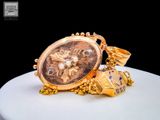 a gold watch with a chain around it on a table