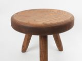 une image représentant un petit tabouret en bois posé sur une surface blanche
