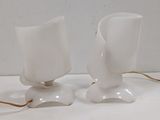 two white vases sitting on a white table