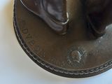 a bronze statue of a man and a woman on a coin