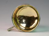 a silver and gold cup with a handle on a white surface