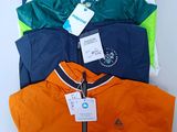 several jackets are stacked on top of each other on a white surface