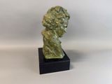 a statue of a man ' s head on a black base