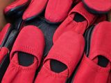 de nombreuses paires de chaussures rouges dans une boîte posée par terre