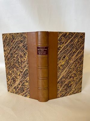 an old book sitting on top of a white cloth covered table
