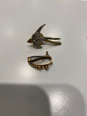 deux paires de boucles d'oreilles posées sur une surface blanche
