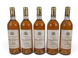 quatre bouteilles de vin posées les unes à côté des autres sur une surface blanche