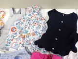 a lot of clothes that are laying out on a bed