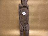 statue of a man holding a sign on a brown background