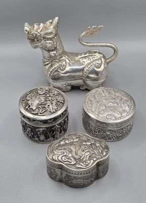 a group of four silver objects including a lion and a box