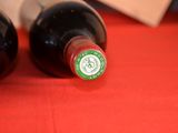 two bottles of wine sitting on a red table