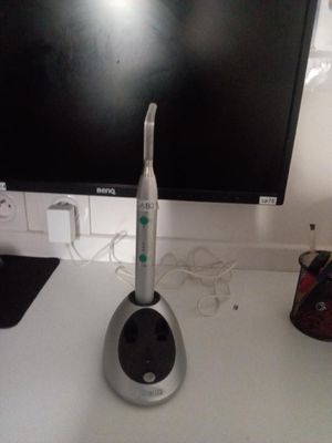 une brosse à dents posée sur un bureau, à côté d'un écran