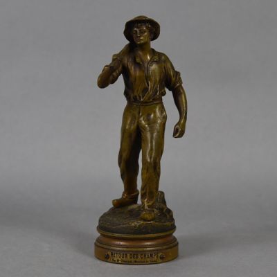 a bronze statue of a man holding a baseball bat on top of a wooden base