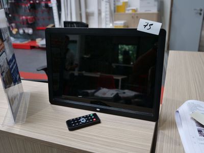un téléviseur posé sur une table, avec une télécommande dessus