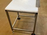 une petite table blanche à roulettes posée au sol