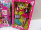 two barbie dolls are in a pink box on a white surface
