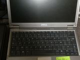 a laptop computer sitting on a desk with a sticky note attached to it