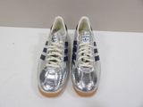 silver and blue sneakers with white laces on a white surface