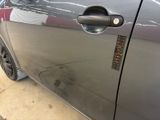 a close up of a car door handle with a sticker on it