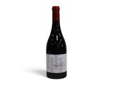 une bouteille de vin rouge posée sur une table blanche