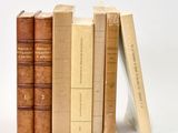 plusieurs vieux livres sont empilés sur une surface blanche