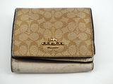 portefeuille Coach beige et noir sur fond blanc
