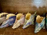 Plusieurs paires de chaussures sont alignées sur une étagère en bois