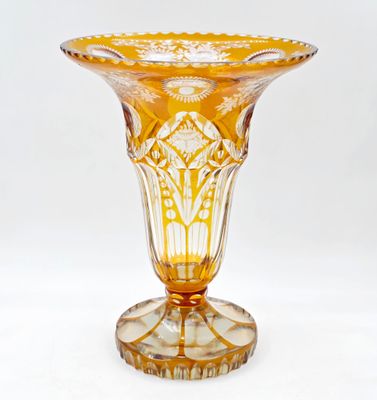 un vase en verre jaune posé sur une table blanche