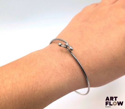 someone is wearing a silver bracelet with a star design on it