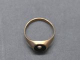 a close up of a gold ring with a black stone in the middle
