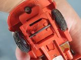 a person holding a red toy car in their hand