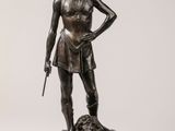 statue en bronze représentant une femme tenant un fusil et un chien