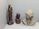 many statues of men and women on display in a museum