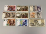 Plusieurs billets de banque différents sont disposés en rangée sur une table