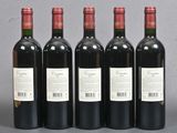 four bottles of wine are lined up on a table