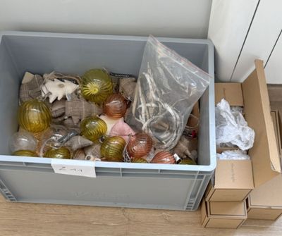 un bac en plastique rempli de décorations de Noël posé par terre