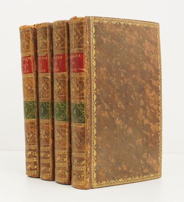 trois vieux livres posés l'un sur l'autre sur une surface blanche