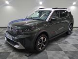 Le SUV vert est garé sur le sol à damier du garage.