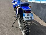 a blue dirt bike parked on the side of the road