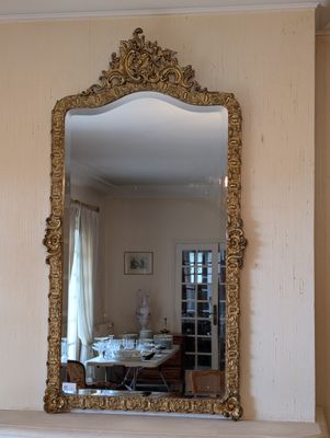 a mirror on the wall above a fireplace in a living room