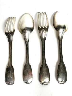 four forks and spoons are lined up on a white surface