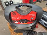 un groupe électrogène portable rouge et noir posé sur une table
