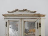 a white cabinet with a mirror on top of it