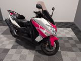 un scooter garé dans une pièce au sol carrelé