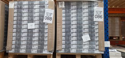 deux palettes chargées de cartons contenant des matelas dans un entrepôt