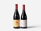 two bottles of wine sitting next to each other on a white surface