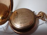 a close up of a gold pocket watch on a white surface