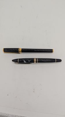 deux stylos à plume noirs et dorés posés sur une surface blanche