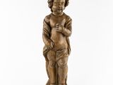 a small wooden statue of a boy holding a baby